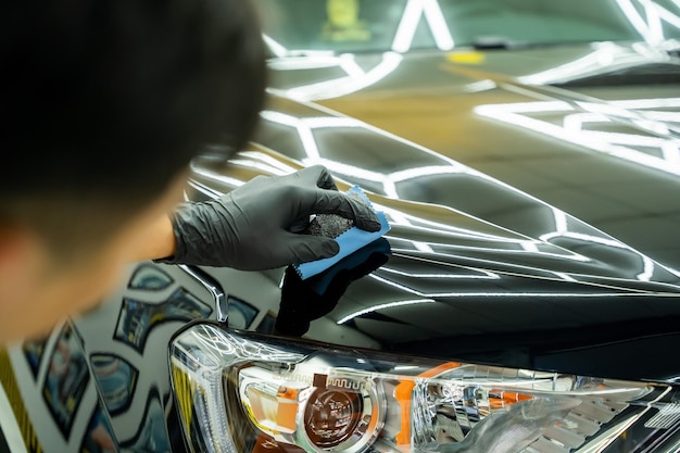 La mano dell'uomo si prende cura della manutenzione dell'auto in garage