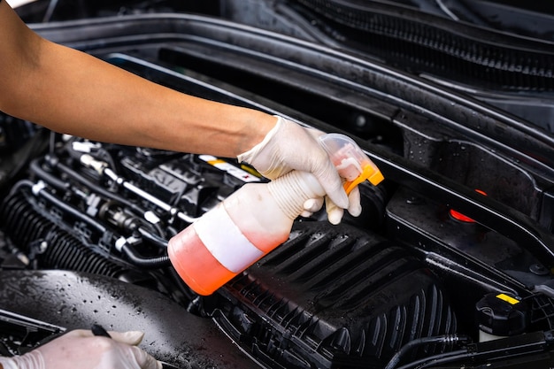 La mano dell'uomo sta mantenendo il motore dell'auto