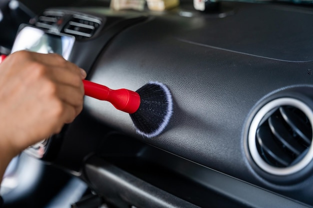 La mano dell'uomo sta pulendo l'auto in garage