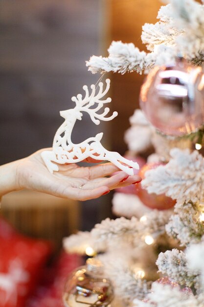 La mano della donna che tiene un giocattolo dell'albero di Natale