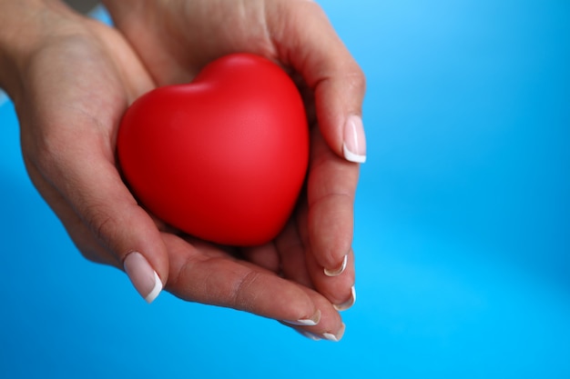 La mano della donna con il manicure tiene un cuore