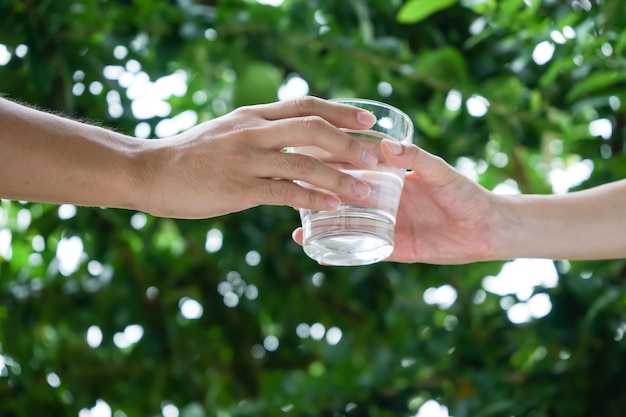 La mano della donna dà acqua potabile