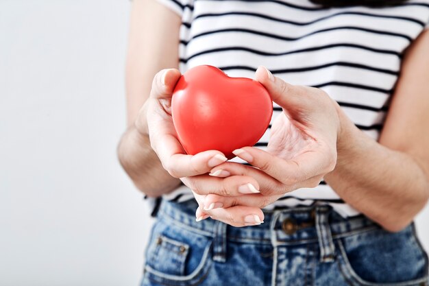 La mano della donna sta tenendo un cuore rosso