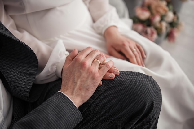 La mano della donna su una sedia con un anello d'oro alla sposa