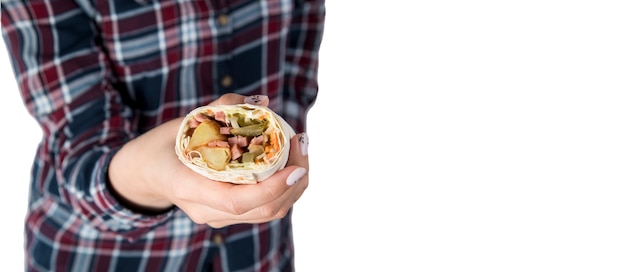 La mano della donna tiene il kebab di shawarma su un fondo bianco. Isolato