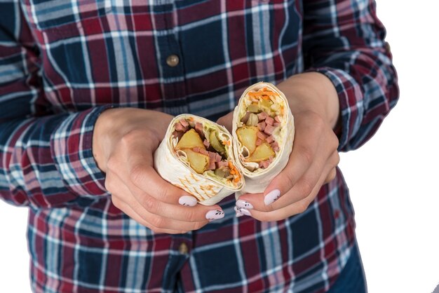 La mano della donna tiene il kebab di shawarma su un fondo bianco. Isolato