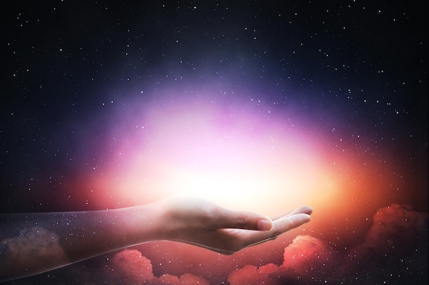 La mano della persona contro il campo stellare di notte