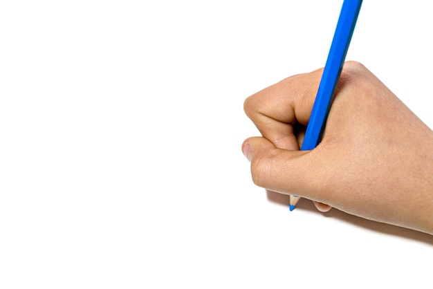 La mano della ragazza che scrive con una matita blu su un foglio bianco.