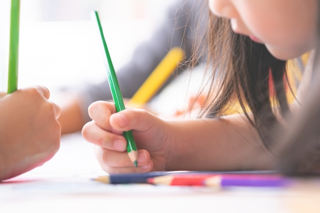 La mano della ragazza sta assorbendo l&#39;aula di arte di asilo