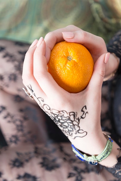 La mano della ragazza tiene un'arancia