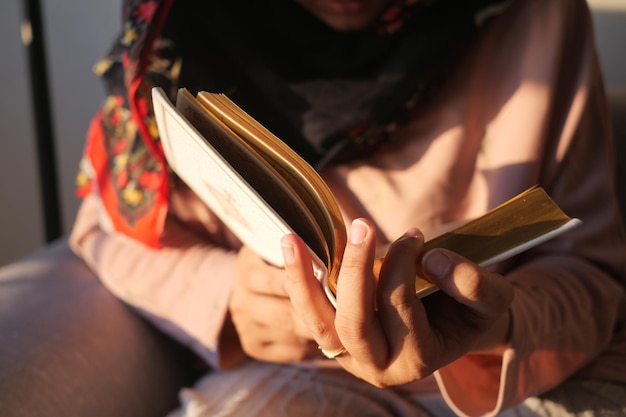 La mano delle donne musulmane che legge il Corano di notte