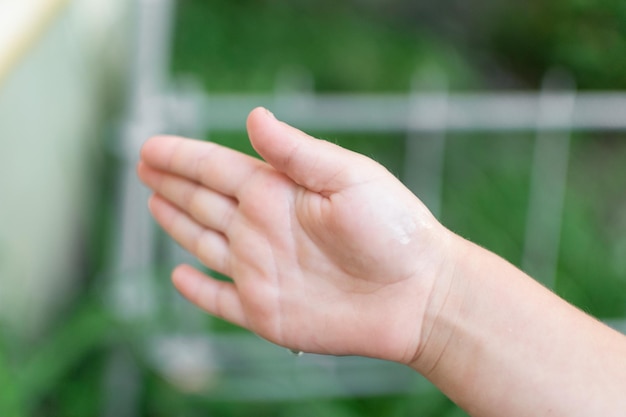 La mano di un bambino cattura una goccia d'acqua