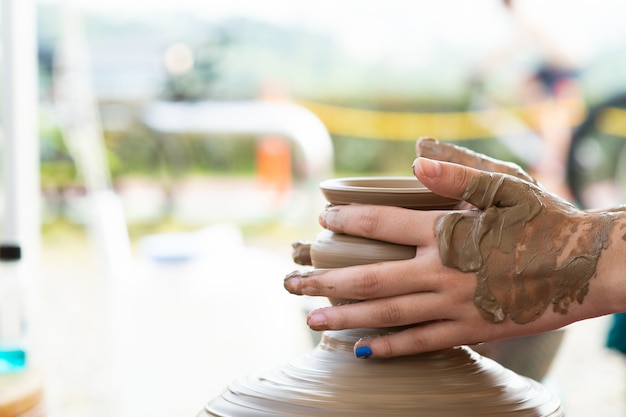 È la mano di un bambino che produce ceramiche.