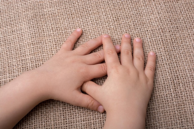 La mano di un bambino con uno sfondo di tela