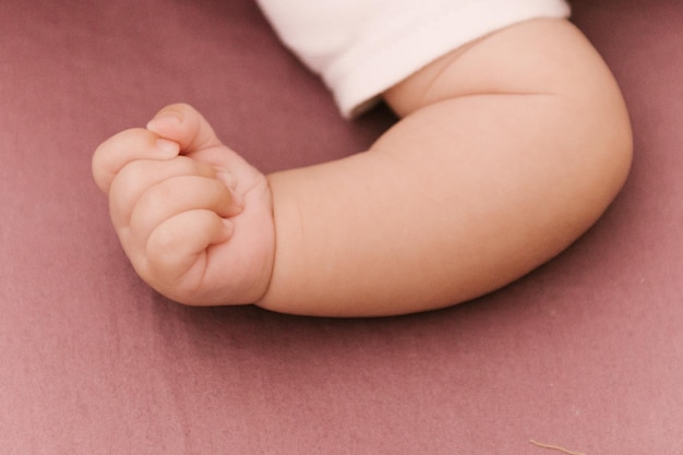 La mano di un bambino piccolo su uno sfondo rosa