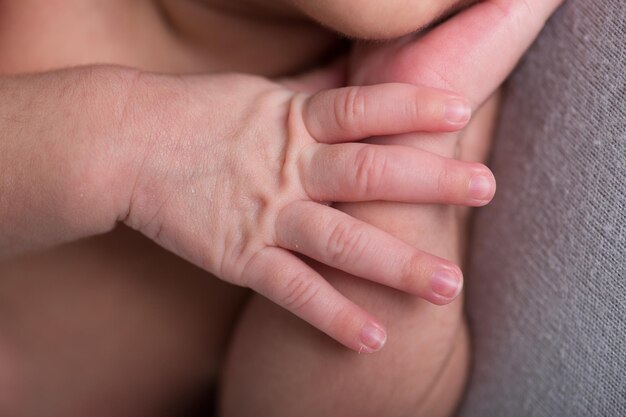 La mano di una donna le tiene il mento e la mano la tocca.