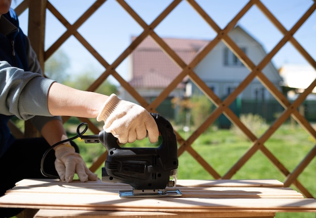 la mano di una donna tiene in mano una sega elettrica. concetto di ristrutturazione della casa