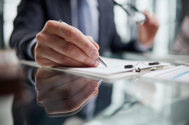 La mano fa le note su un primo piano del taccuino di carta