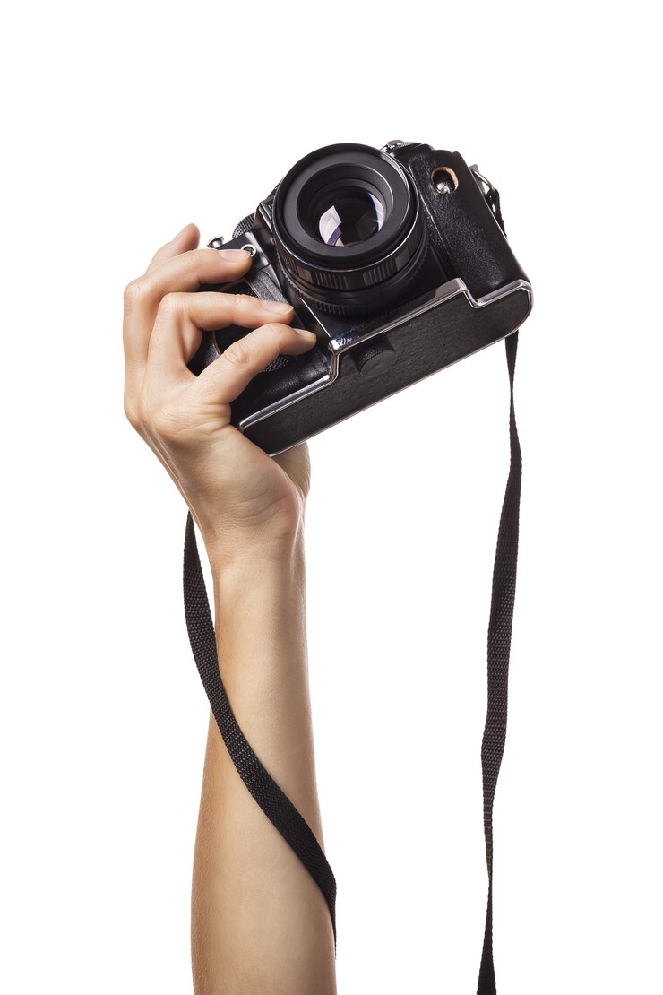 La mano femminile alzata tiene una macchina fotografica isolata su fondo bianco