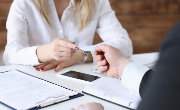 La mano femminile in abito dà un biglietto da visita vuoto maschio