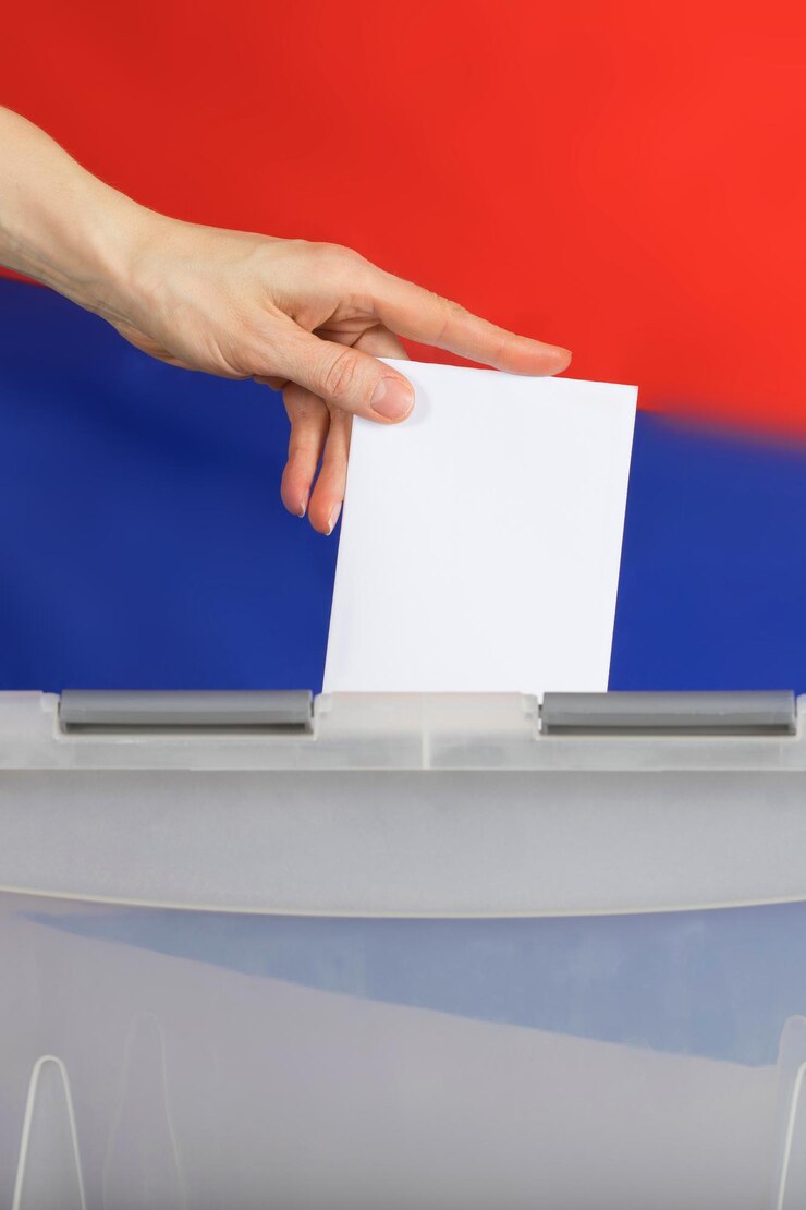 Foto la mano femminile lancia la scheda elettorale nell'urna. bandiera russa sullo sfondo.