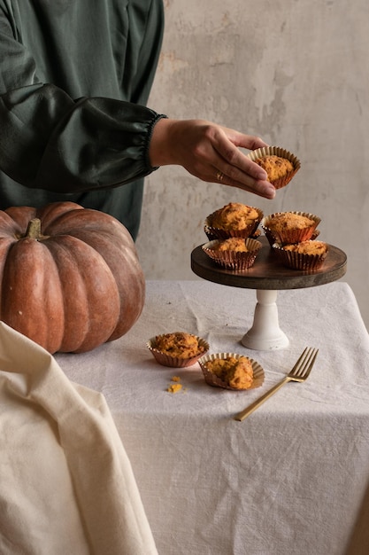 La mano femminile prende i tortini della spezia della zucca dal vassoio verticale