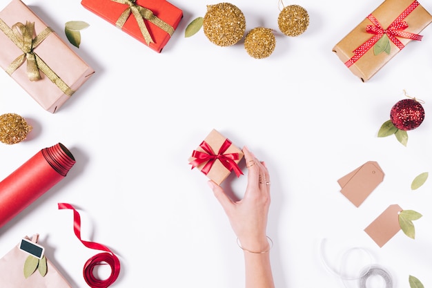 La mano femminile prende una piccola scatola con un regalo