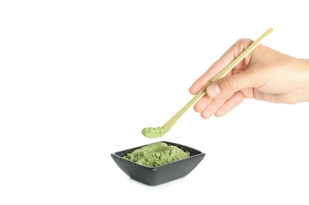 La mano femminile tiene il bastone con polvere di matcha, isolato su sfondo bianco