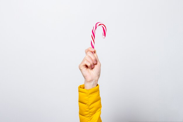 La mano femminile tiene il lolipop isolato