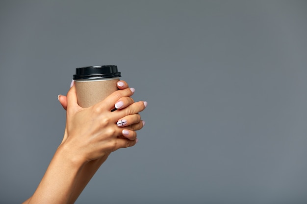 la mano femminile tiene una tazza di caffè del Libro Bianco, copyspace