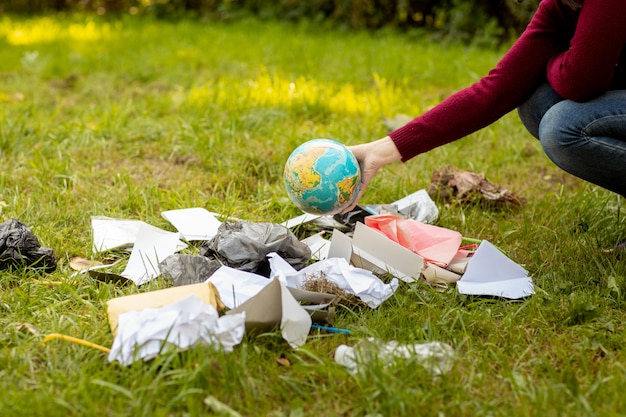 La mano lancia un globo nella spazzatura.