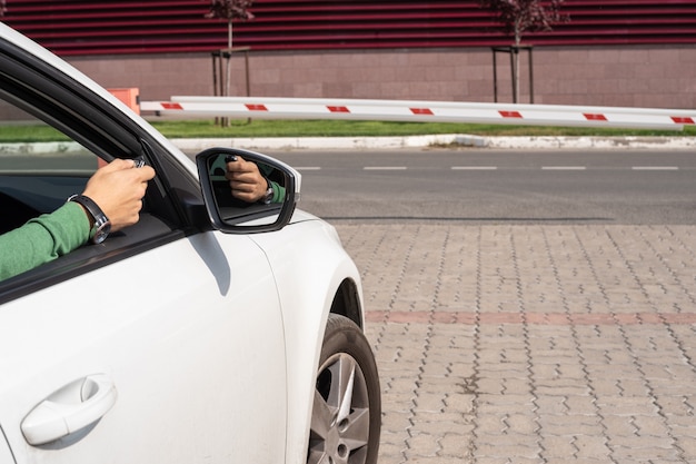 La mano maschile con il telecomando si apre una barriera dall'interno dell'auto