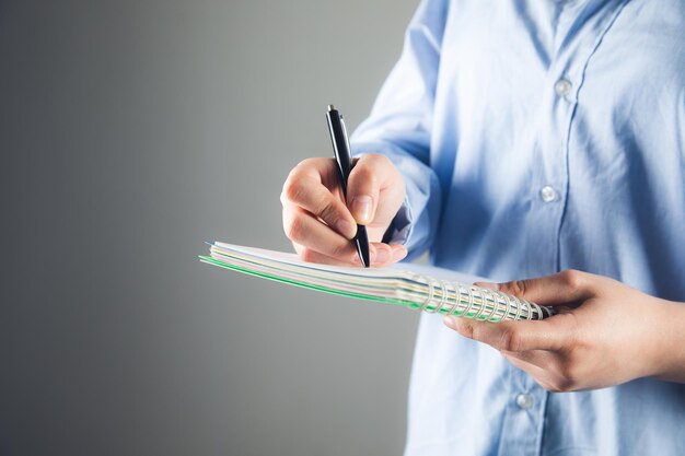 La mano scrive con una penna in un taccuino