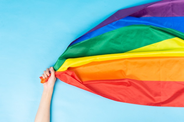 La mano sta tenendo la bandiera arcobaleno