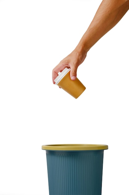 La mano su fondo bianco getta la tazza usa e getta di caffè da asporto nel cestino. Riciclaggio ed ecologia.