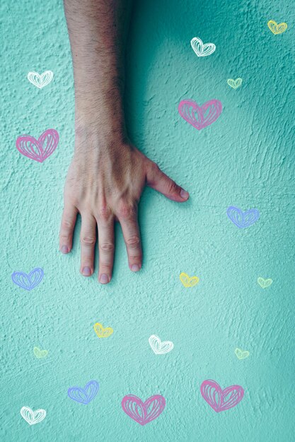 la mano sulla parete blu con i cuori modella il giorno di san valentino