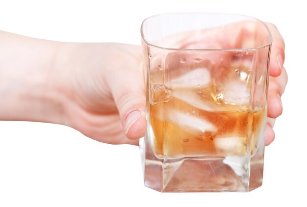 La mano tiene il whisky su ghiaccio in vetro isolato