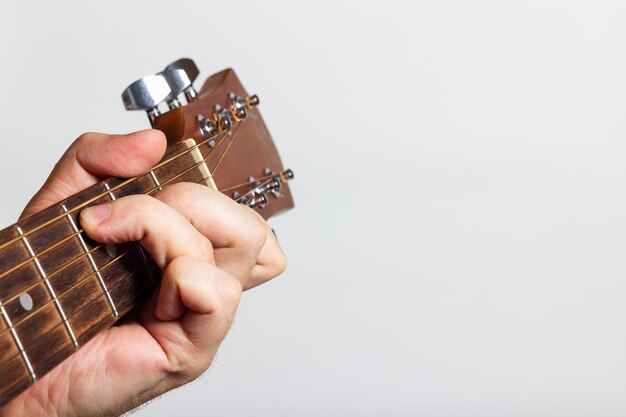 la mano tiene una chitarra su uno sfondo bianco