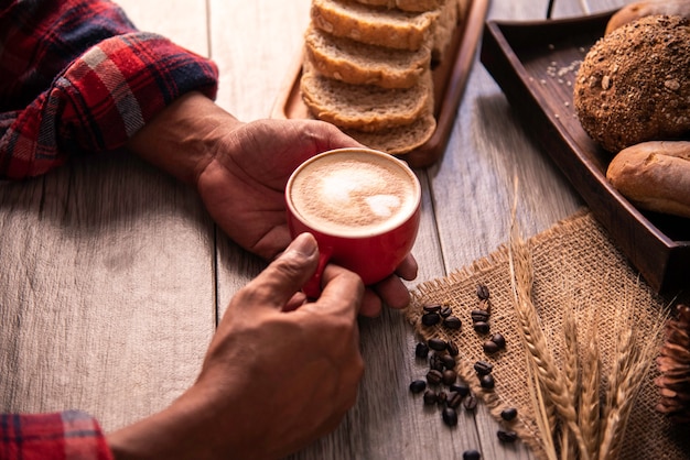 La mano tiene una tazza di caffè rossa. concetto ancora vita