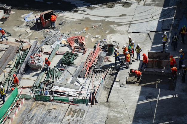 La manodopera asiatica e i lavoratori tailandesi utilizzano macchine e macchinari pesanti per il lavoro del costruttore di una nuova torre di costruzione nel sito in costruzione grattacielo sull'impalcatura nella capitale a Bangkok in Thailandia