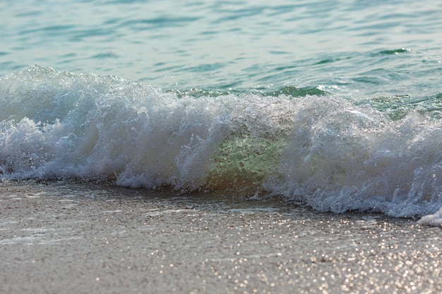 La marea del mare spruzza il primo piano dell'acqua limpida turbolenta