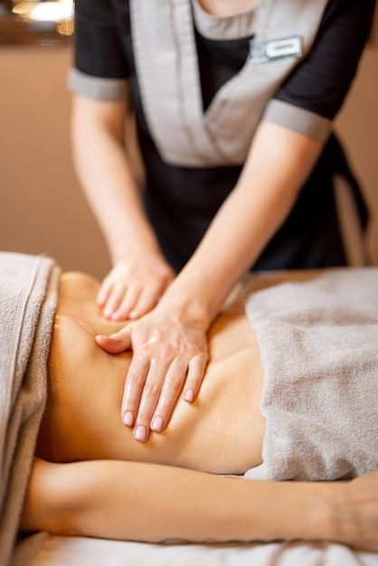 La massaggiatrice esegue un massaggio addominale professionale per una donna