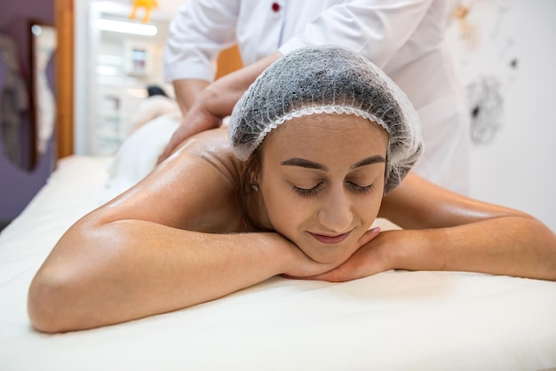 La massaggiatrice massaggia una bella donna in una spa per mostrare la sua figura Schiena sana di stile di vita sano