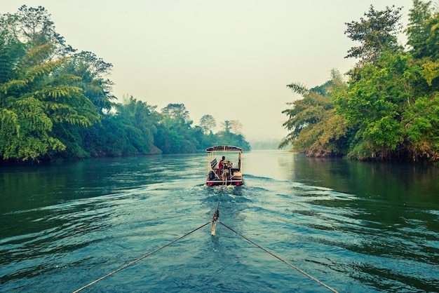 La mattina presto al fiume Kwai in Thailandia con il concetto turistico all'aperto di viaggio in zattera di legno