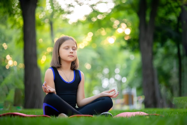 La meditazione nel parco nella posizione del loto la bambina medita e si rilassa