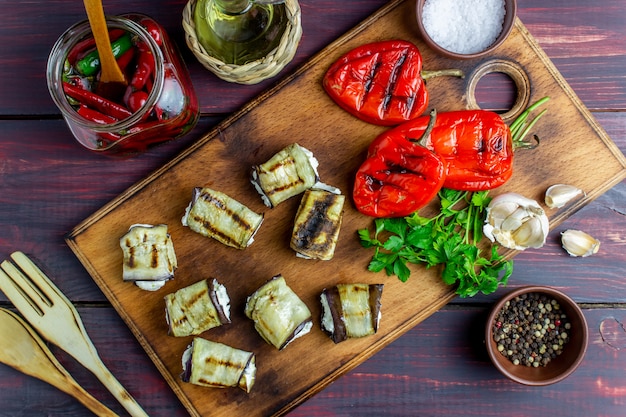 La melanzana rotola con formaggio su un fondo di legno. Mangiare sano.