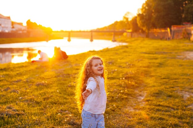 La meravigliosa bambina si coccola sotto i raggi del sole passeggiando lungo il fiume