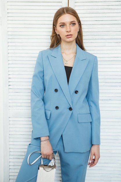 La modella è una ragazza con un tailleur blu che riprende abiti alla moda per lo sfondo dello studio del negozio