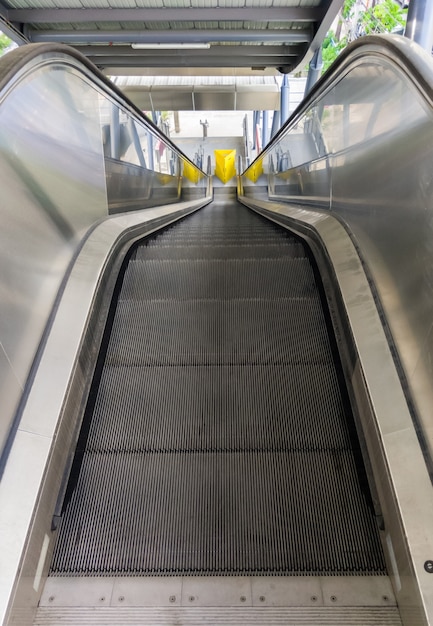 La moderna scala mobile vuota che non è ancora in funzione all'interno della stazione ferroviaria suburbana, scendi alla fermata dell'autobus., vista frontale con lo spazio della copia.