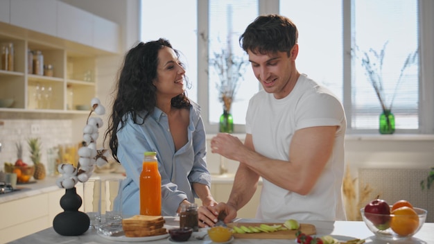 La moglie assaggia la colazione il marito in cucina da vicino coppia felice che mangia mele